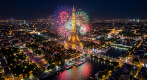 Feu d'artifice depuis la Tour Eiffel la nuit, avec des gerbes colorées illuminant le Champ-de-Mars et la Seine
