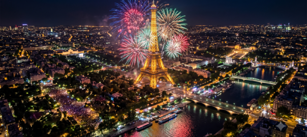 Feu d'artifice depuis la Tour Eiffel la nuit, avec des gerbes colorées illuminant le Champ-de-Mars et la Seine