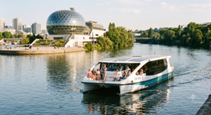 Catamaran électrique de la navette fluviale des Hauts-de-Seine sur la Seine, avec La Seine Musicale et l'Île Seguin en arrière-plan par une belle journée d'été
