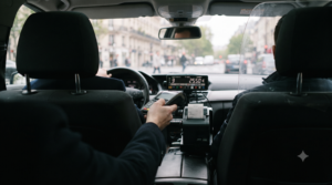 Terminal de paiement par carte bancaire tendu au passager dans un taxi parisien